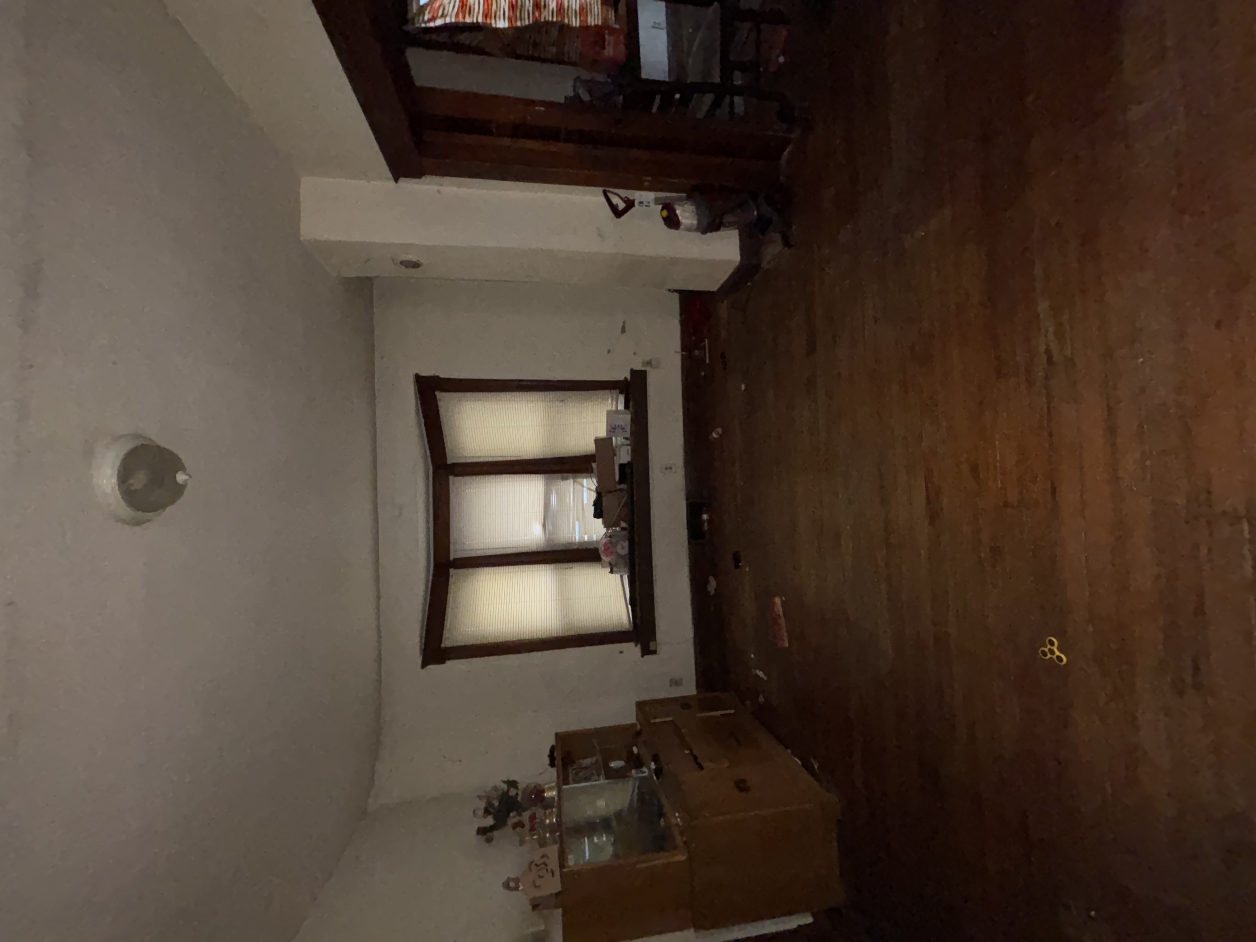 Living room before - dark, damaged floors, clutter