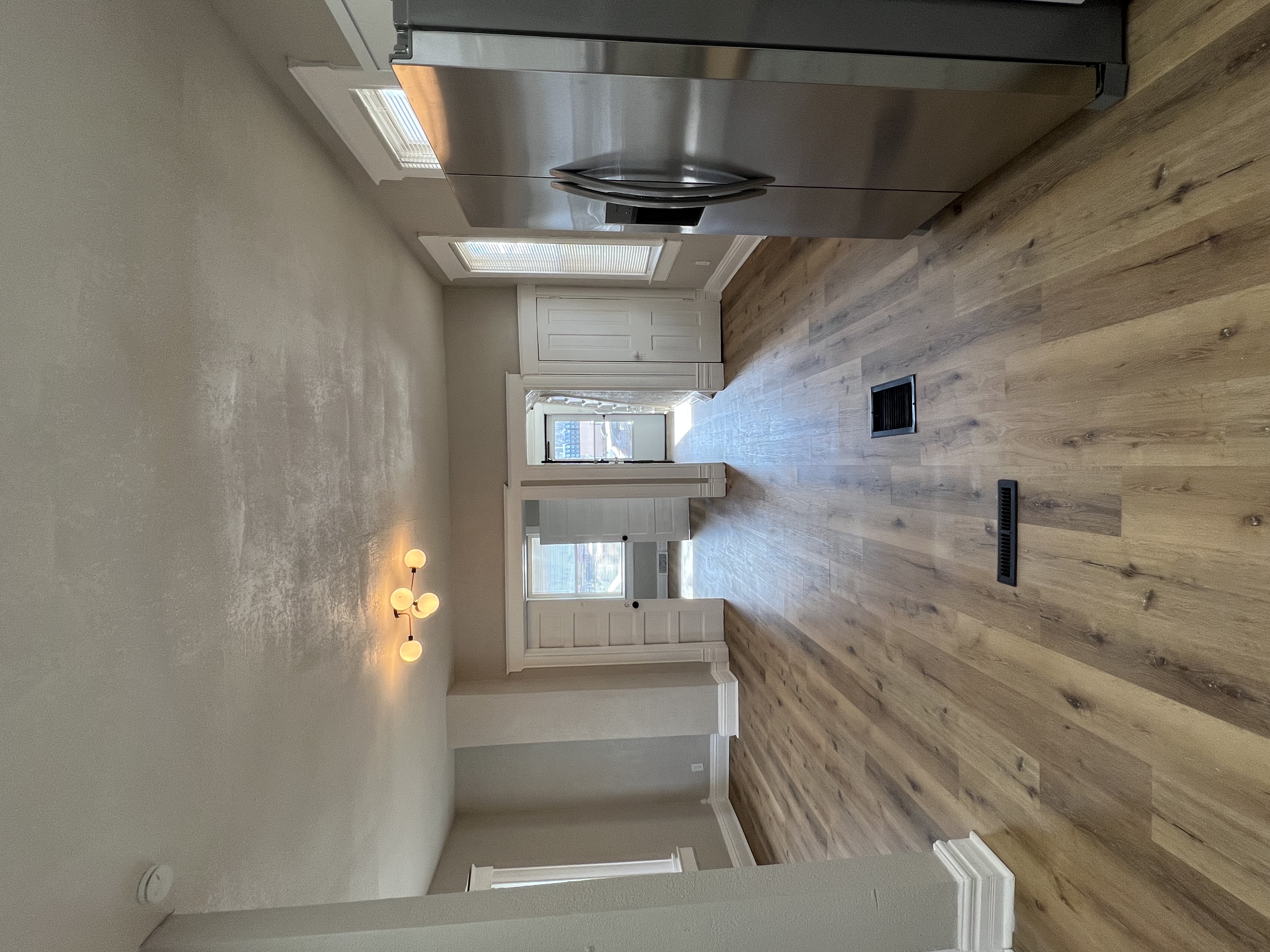 Restored open living space with LVP floors and modern lighting